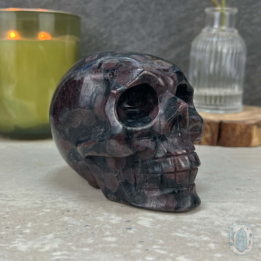 Polished Arfvedsonite and Garnet Firework Skull Carving