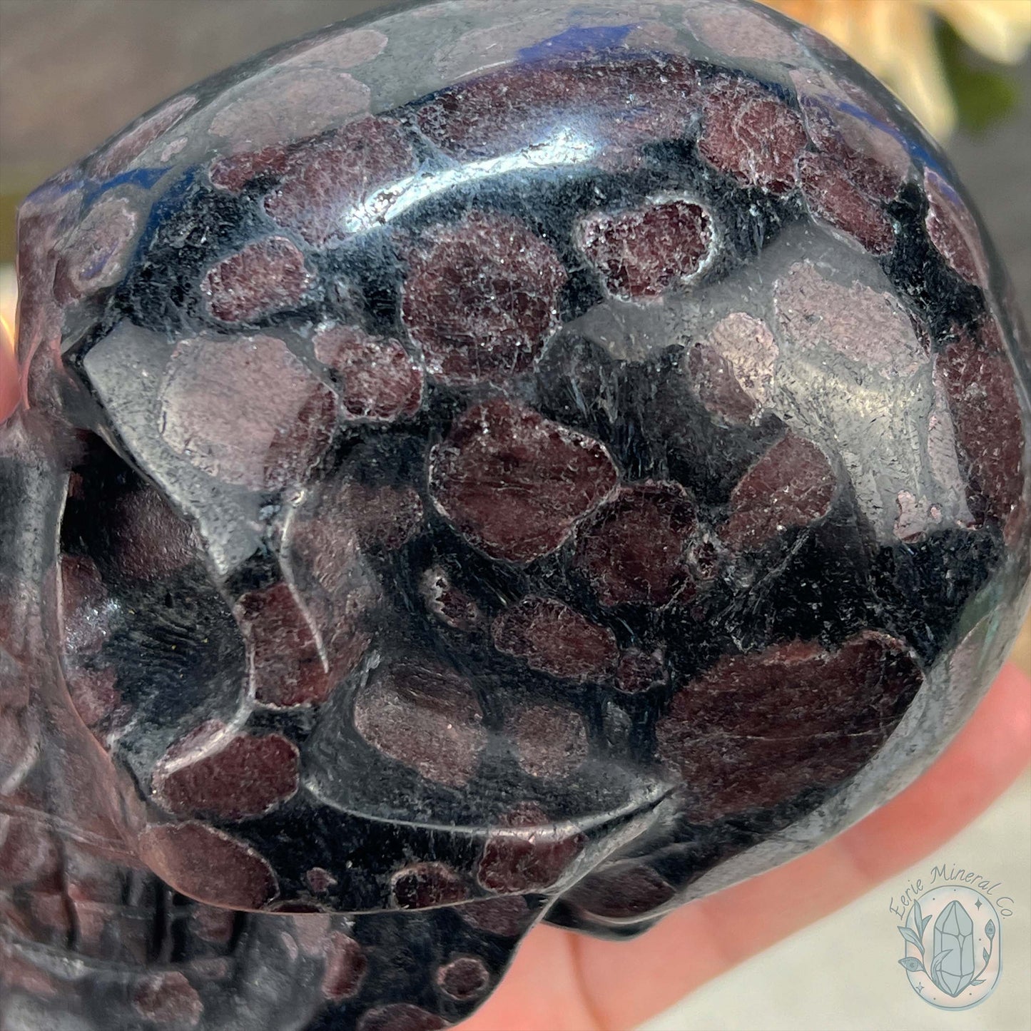 Polished Arfvedsonite and Garnet Firework Skull Carving