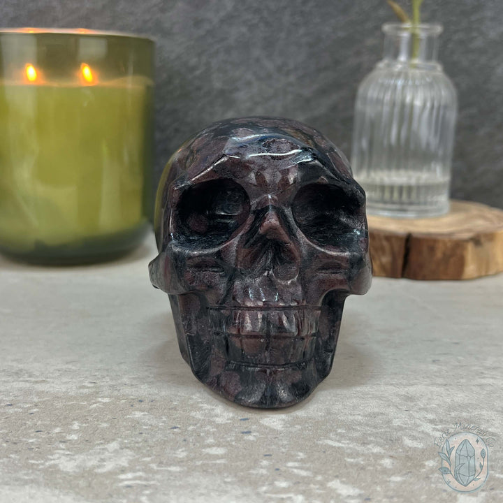 Polished Arfvedsonite and Garnet Firework Skull Carving