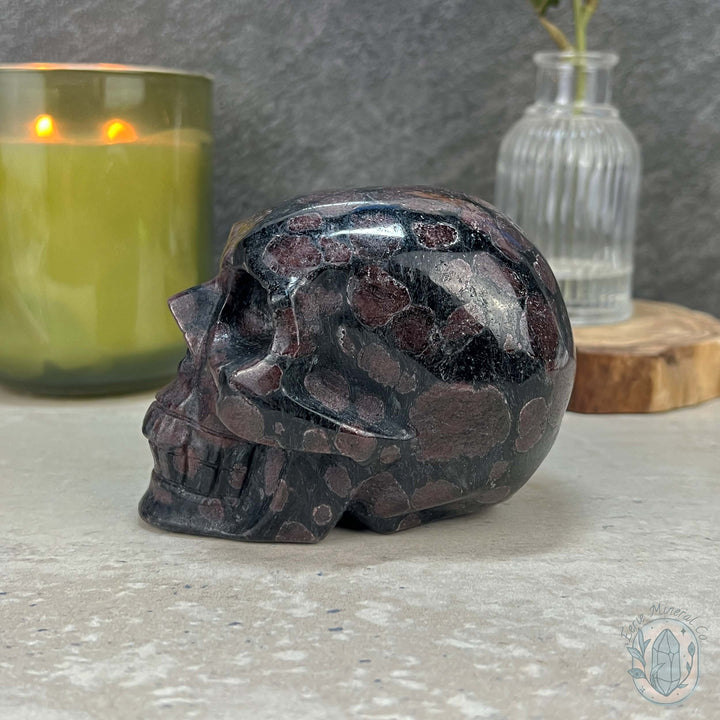 Polished Arfvedsonite and Garnet Firework Skull Carving