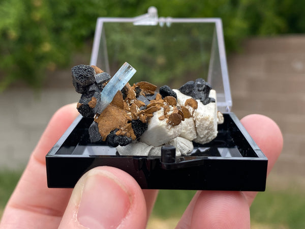 Aquamarine in feldspar with black tourmaline and siderite which is a pseudomorph. This specimen comes from The Republic of Namibia, Southern Africa.