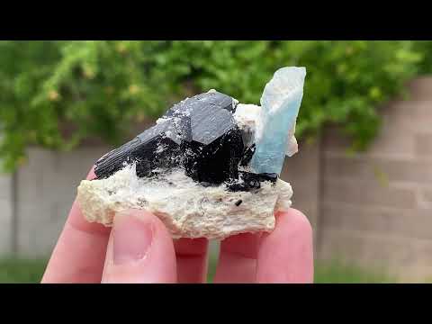 Aquamarine in feldspar with black tourmaline and siderite which is a pseudomorph. This specimen comes from The Republic of Namibia, Southern Africa. 